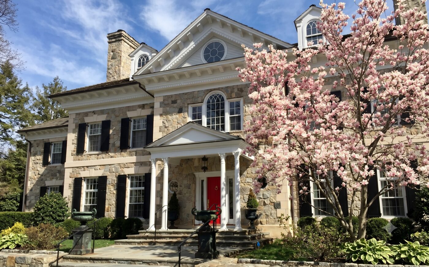 Stone estate home with magnolia tree in bloom