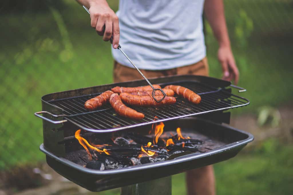 safety important when grilling, as shown in this photo of man charcoal grilling