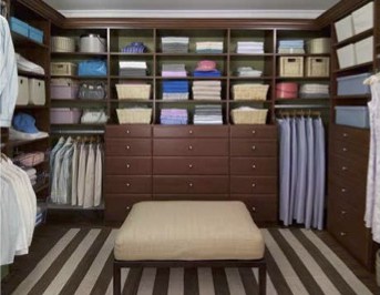 walk-in closet with espresso wood finish and large seat