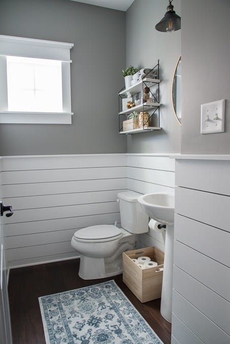 Shiplap wood panelling halfway up wall in powder room