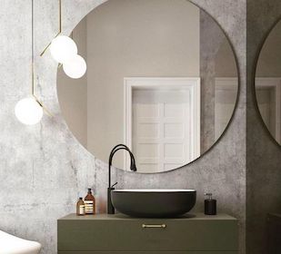 Bathroom vanity lit by pendant lights with big round mirror.