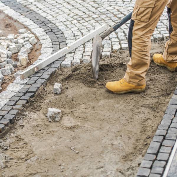 worker paving residential path using granite worker paving residential path using granite